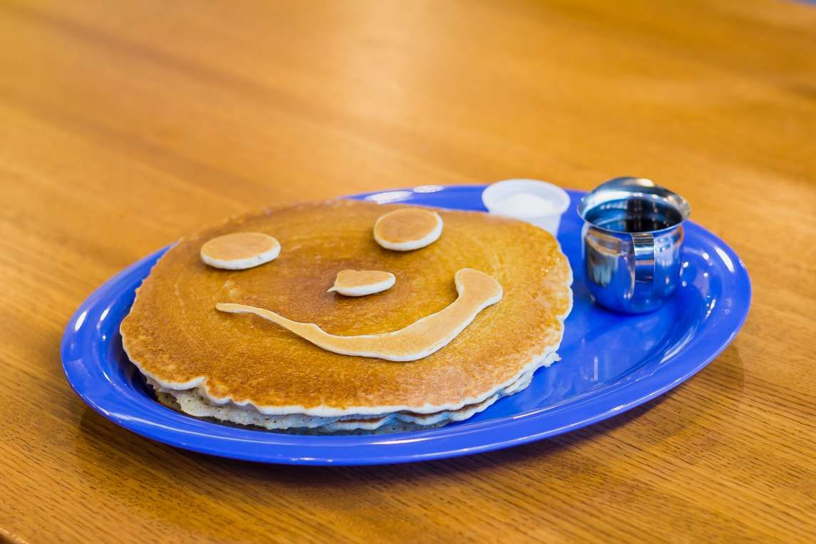 Pancake with a smiley face of banana slices