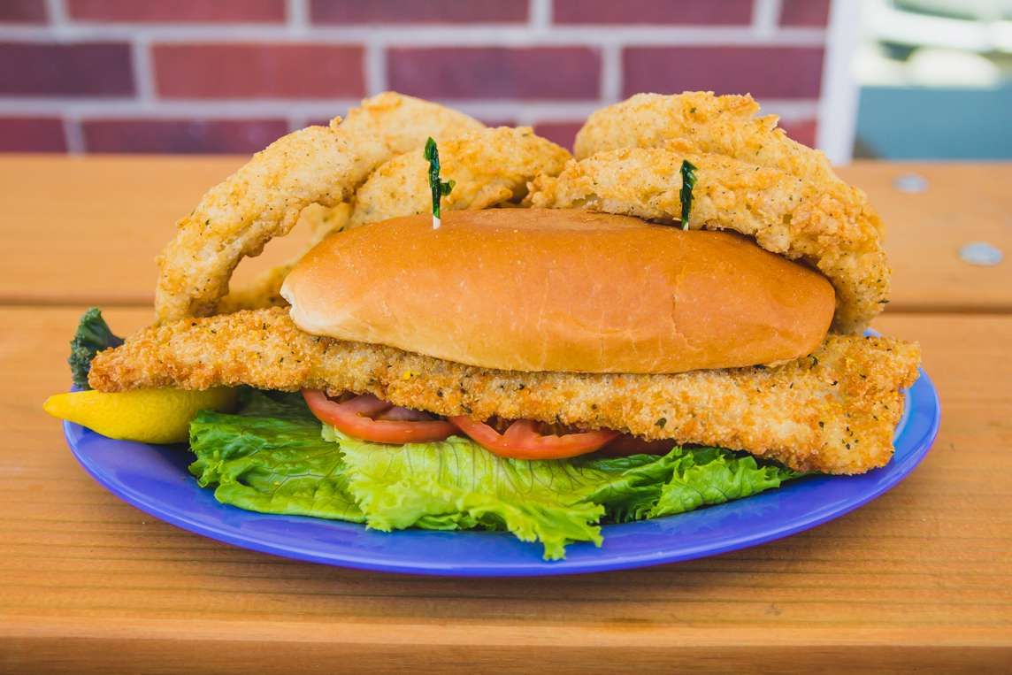 Fried fish po' boy on a blue plate
