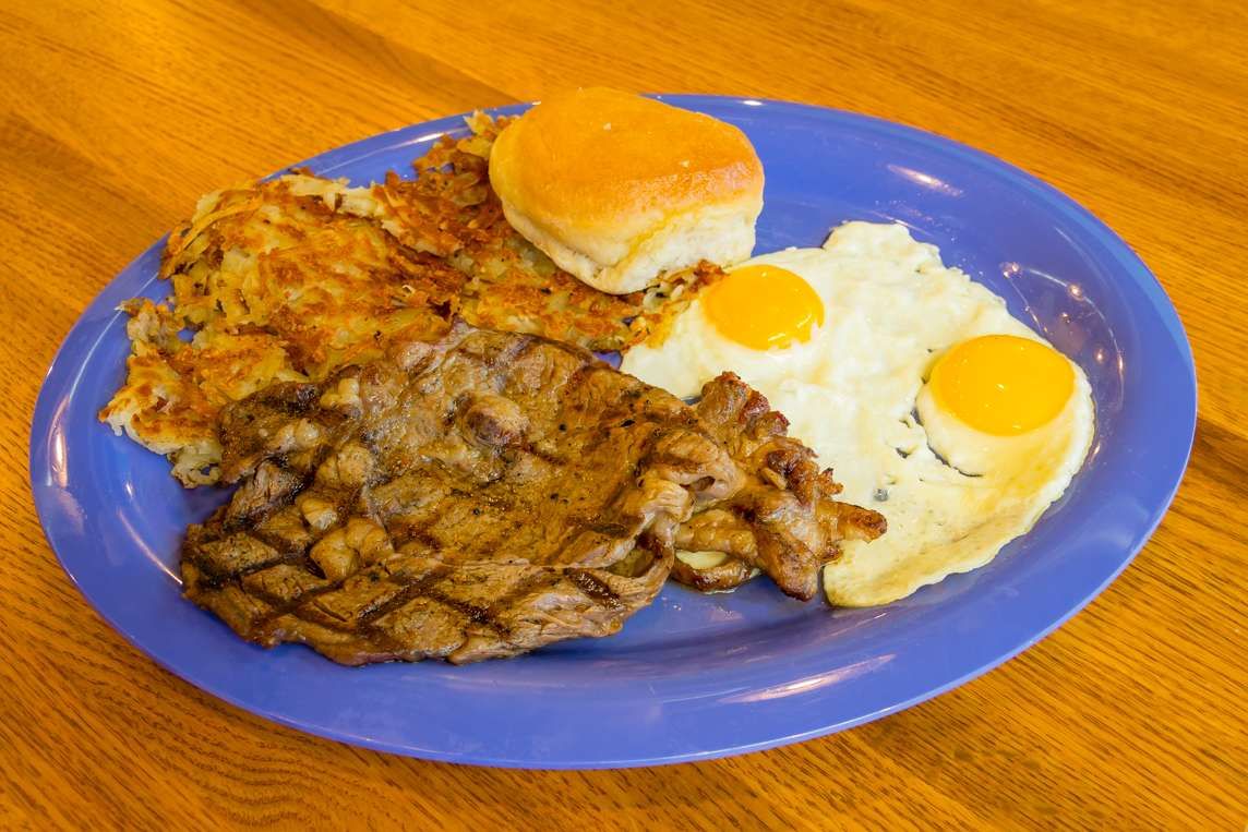 Ribeye steak, fried eggs and a biscuit